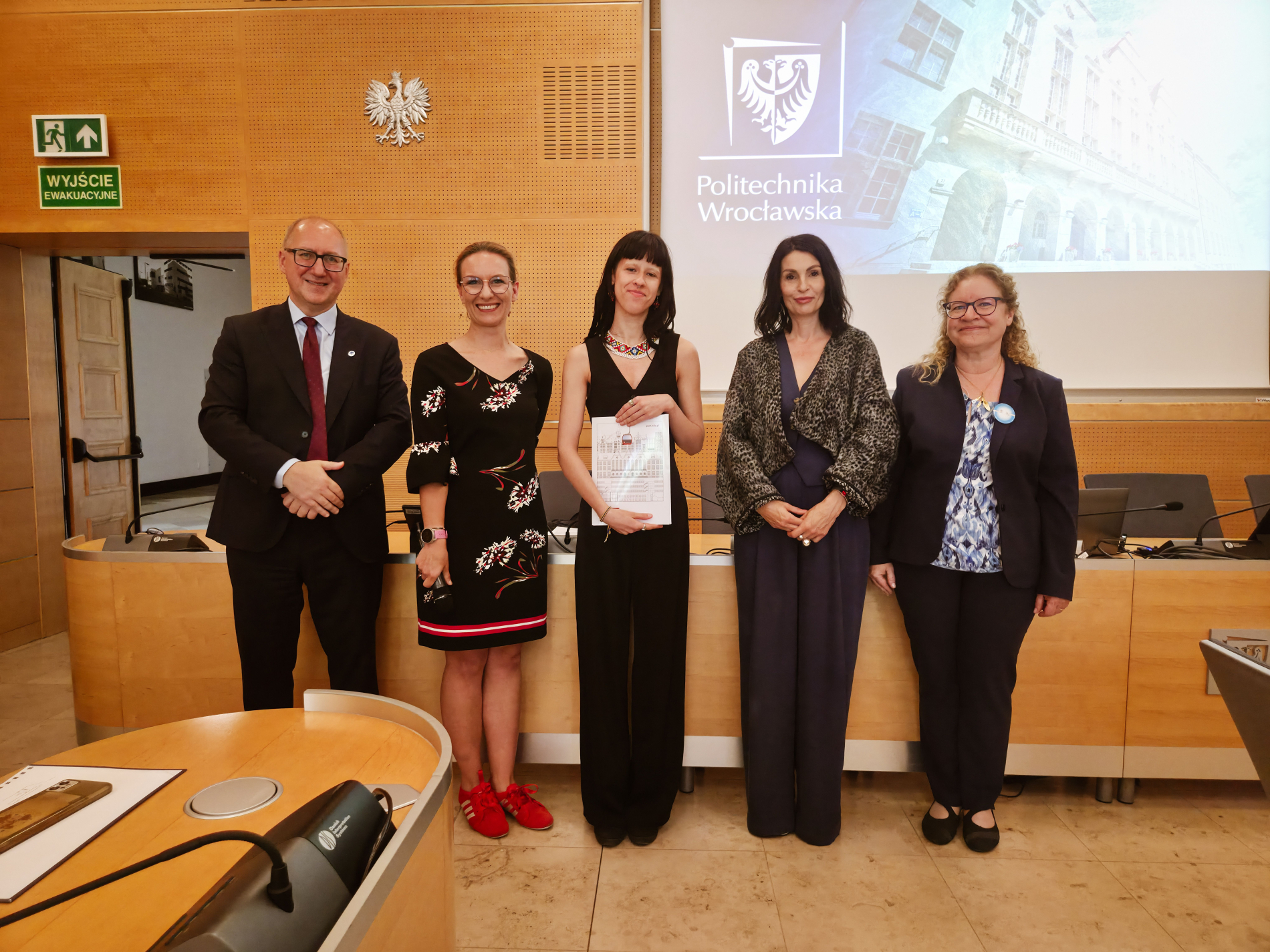 Zdjęcie laureatki trzymającej dyplom z kapitułą konkursu