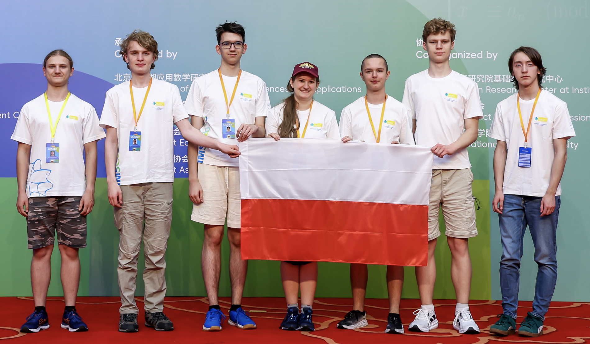 Zdjęcie grupowe reprezentacji Polski, osoby na zdjęciu trzymają Polską flagę