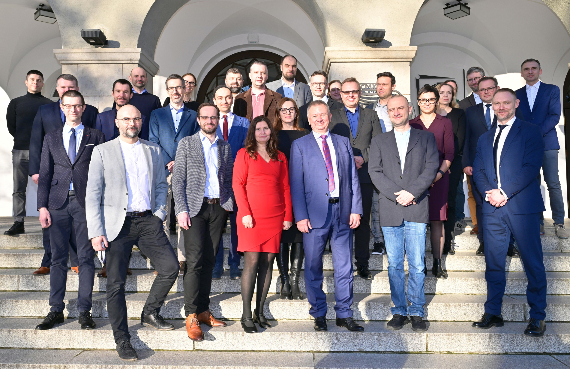 Zdjęcie grupy osób stojących na schodach przed budynkiem PWr