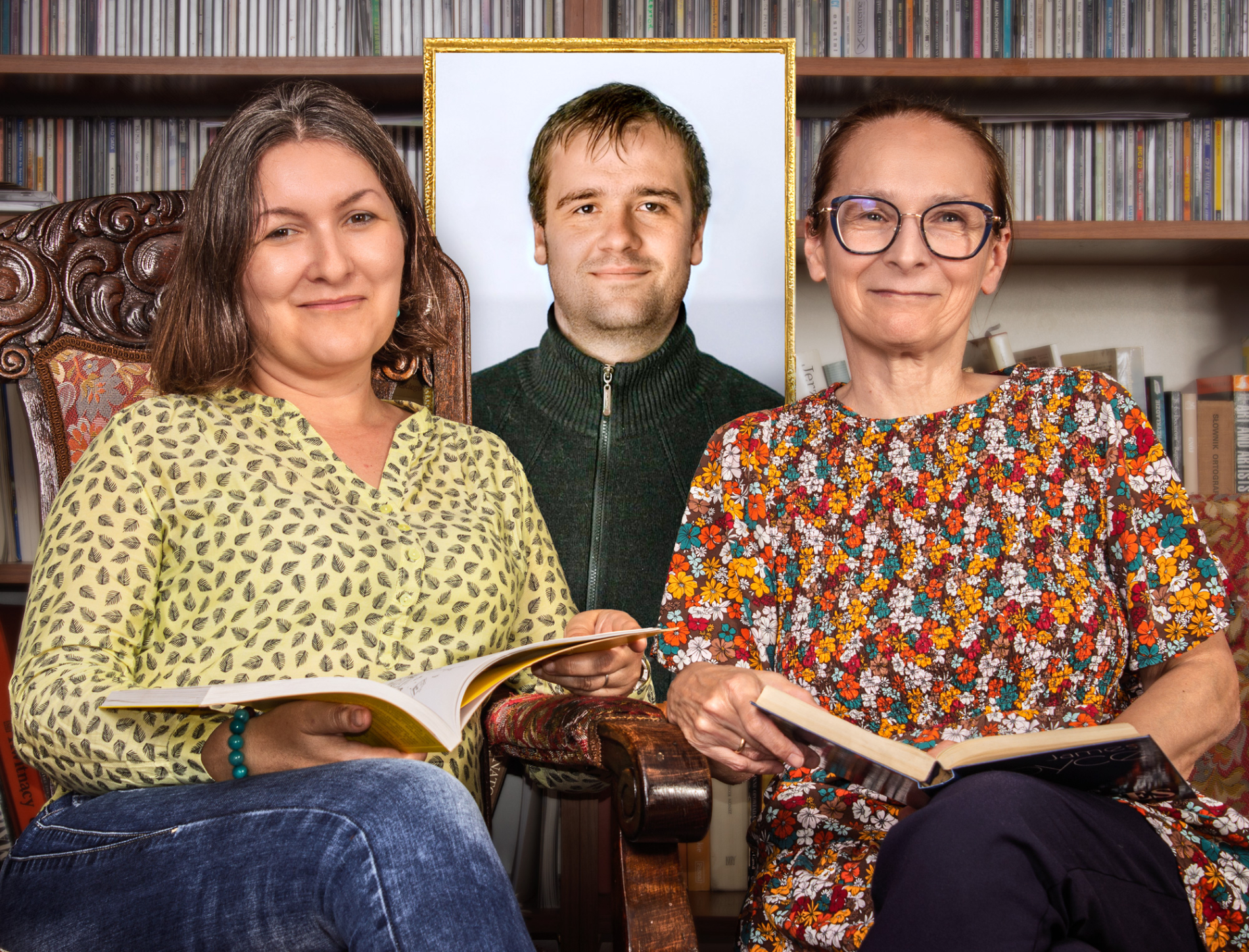 Zdjęcie dwóch osób siedzących na krzesłach, za nimi portret młodego mężczyzny