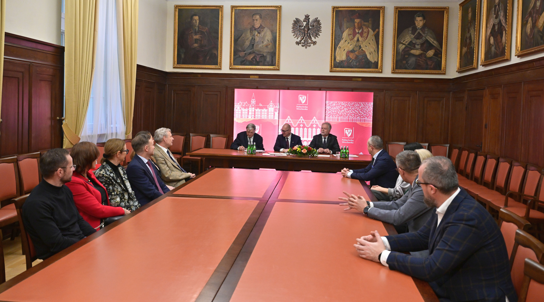 Zdjęcie osób podpisujących umowę w sali Politechniki Wrocławskiej