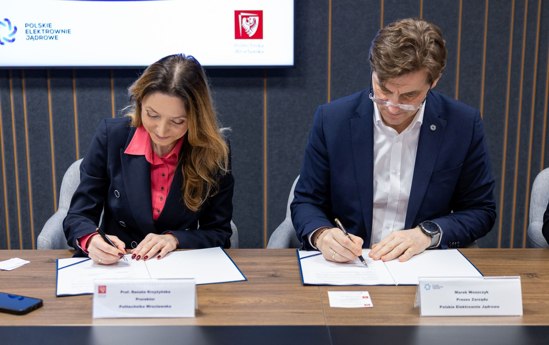 Zdjęcie dwóch osób podpisujących umowę