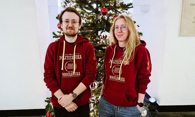 Zdjęcie dwóch osób w bluzach PWr na tle choinki