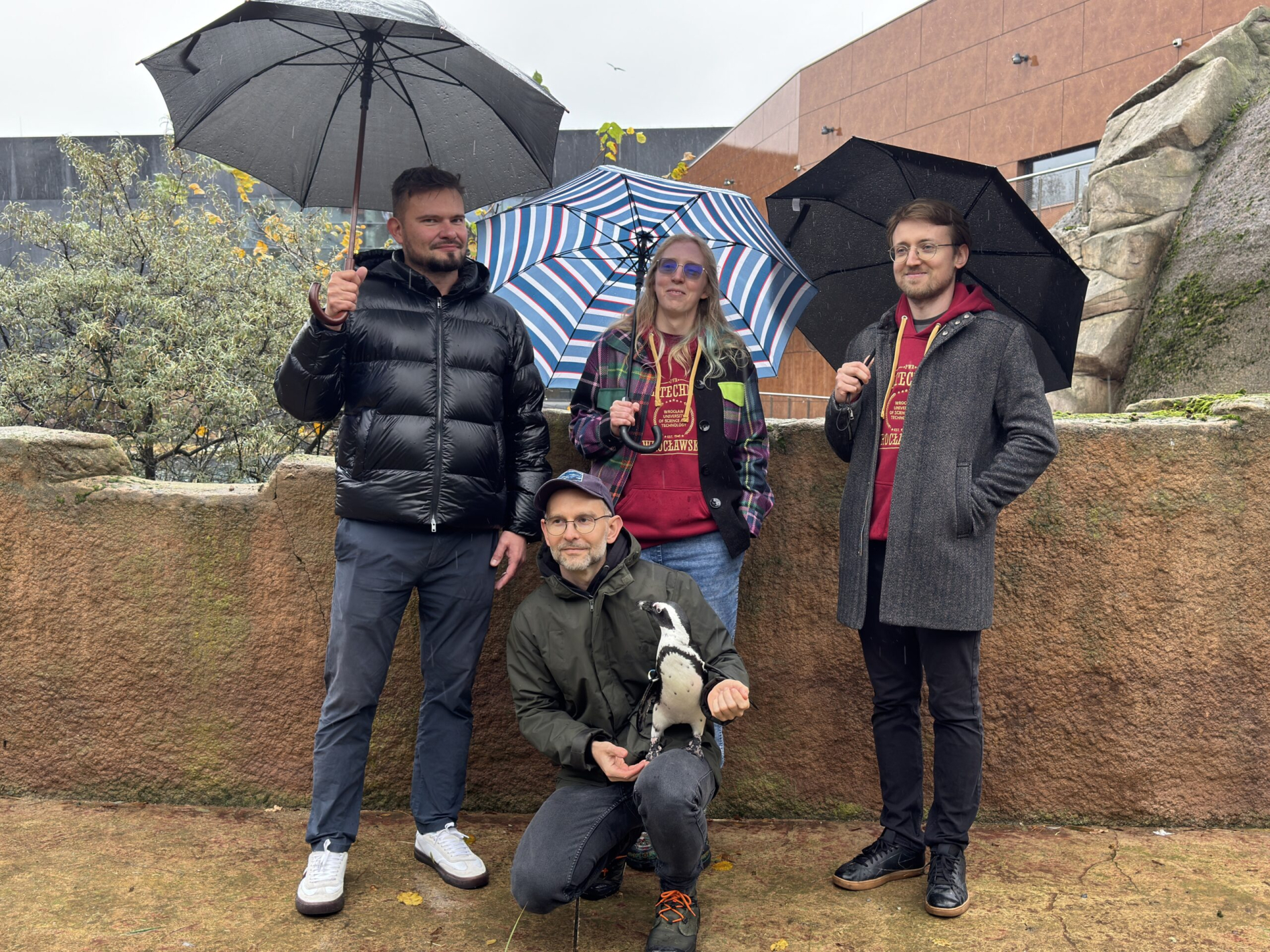 Zdjęcie grupy osób, z których jedna trzyma pingwina