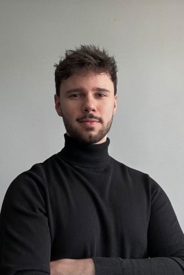 Zdjęcie portretowe: młody mężczyzna z brodą w czarnym golfie