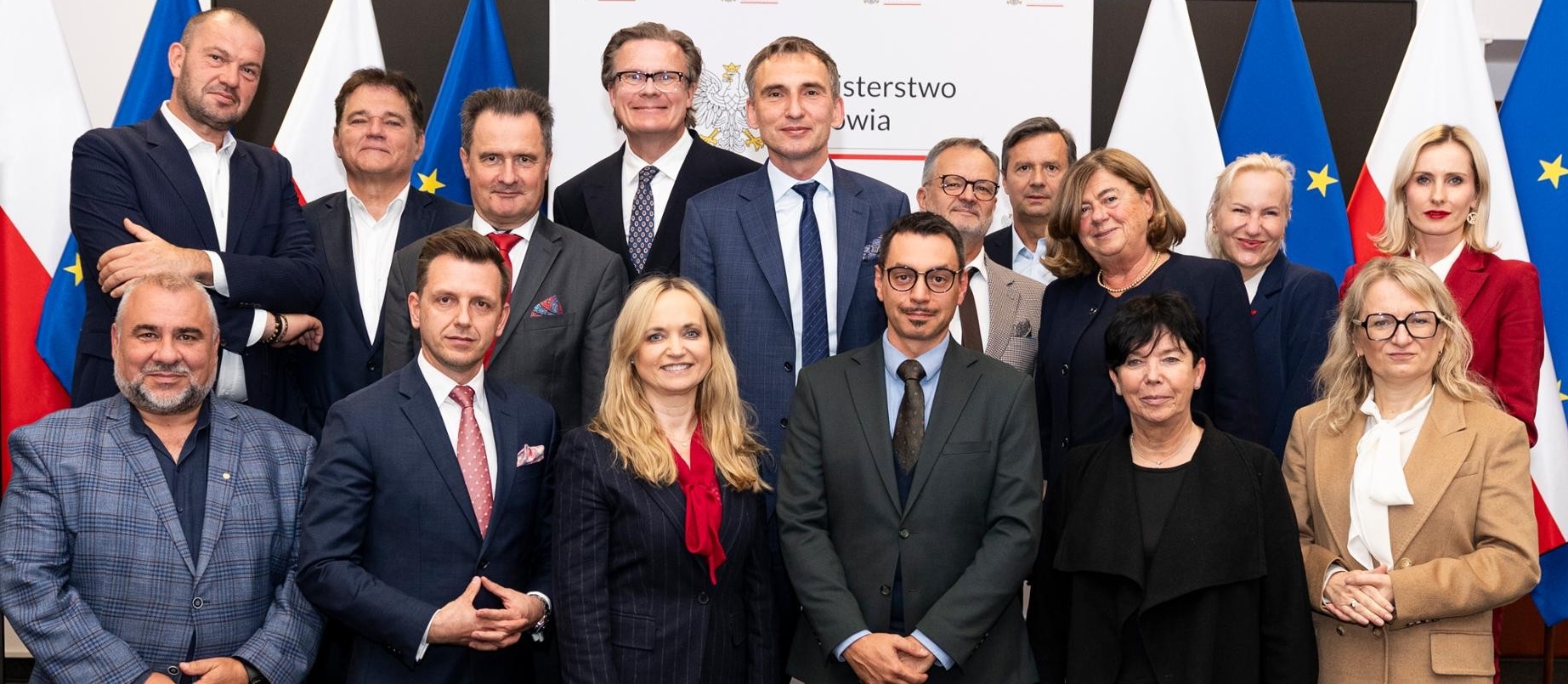 Grupa osób stojąca obok siebie na tle napisu Ministerstwo Zdrowia