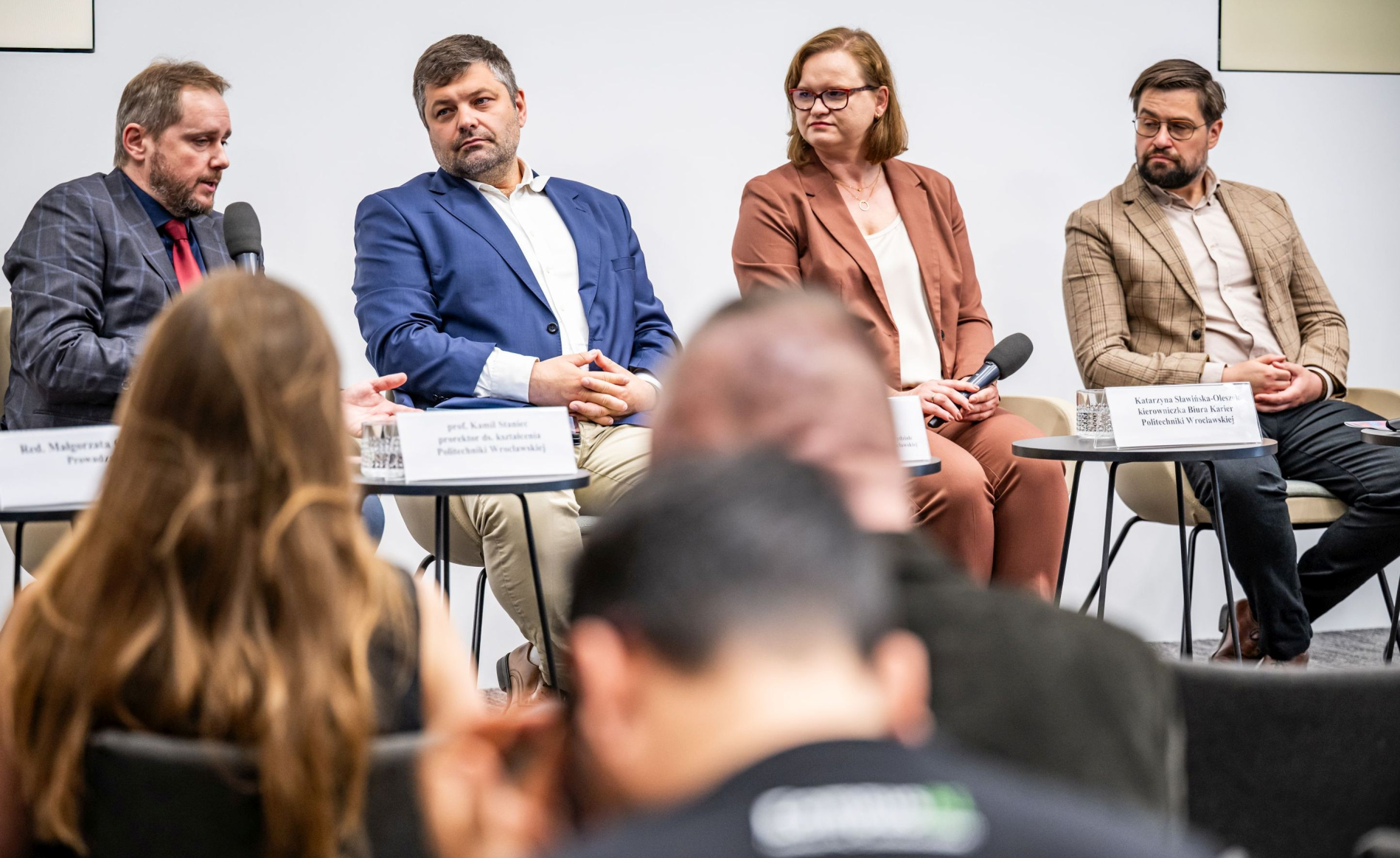 Zdjęcie przedstawia panel dyskusyjny w centrum prasowym PAP. zbliżenie na czterech uczestników panelu, siedzących za stołem, z widocznym fragmentem publiczności na pierwszym planie.