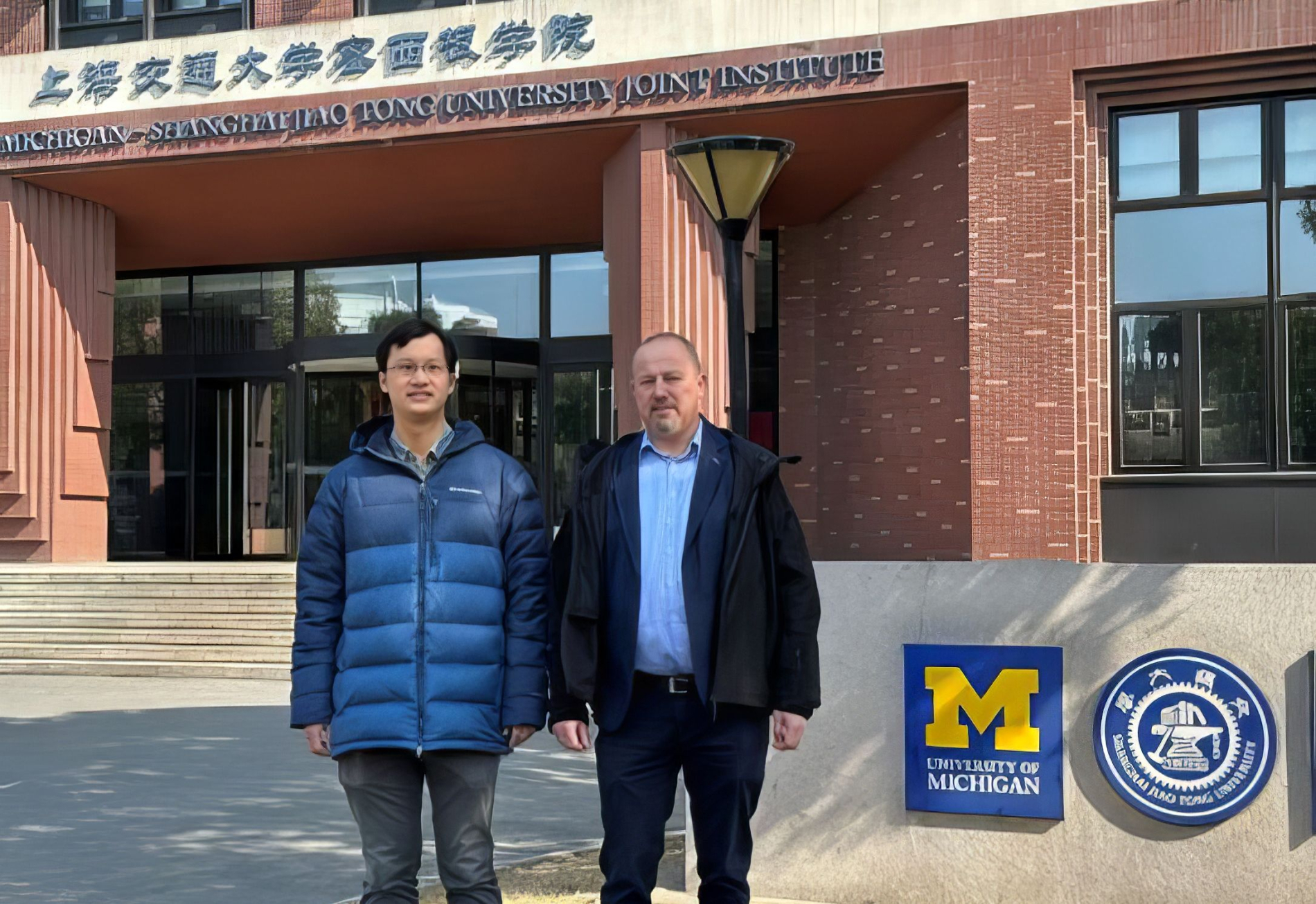 Zdjęcie prof. Roberta Kudrawca i prof. Rui Tanga na tle budynku