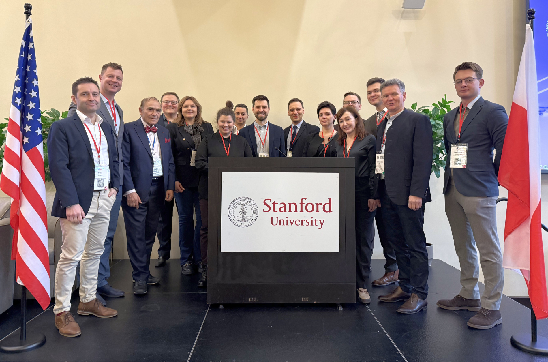 Zdjęcie grupy osób stojących na scenie przed nimi mównica z napisem University of Stanford