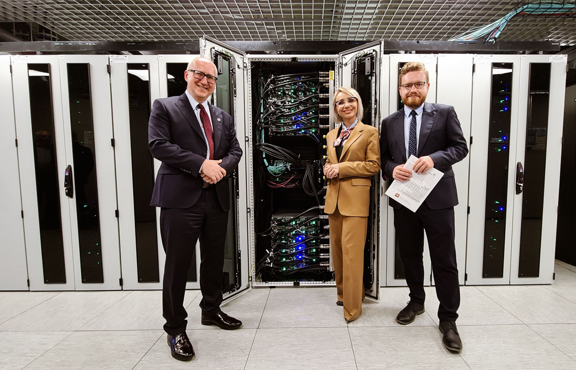 Zdjęcie trzech osób stojących obok siebie na tle szaf komputerowych