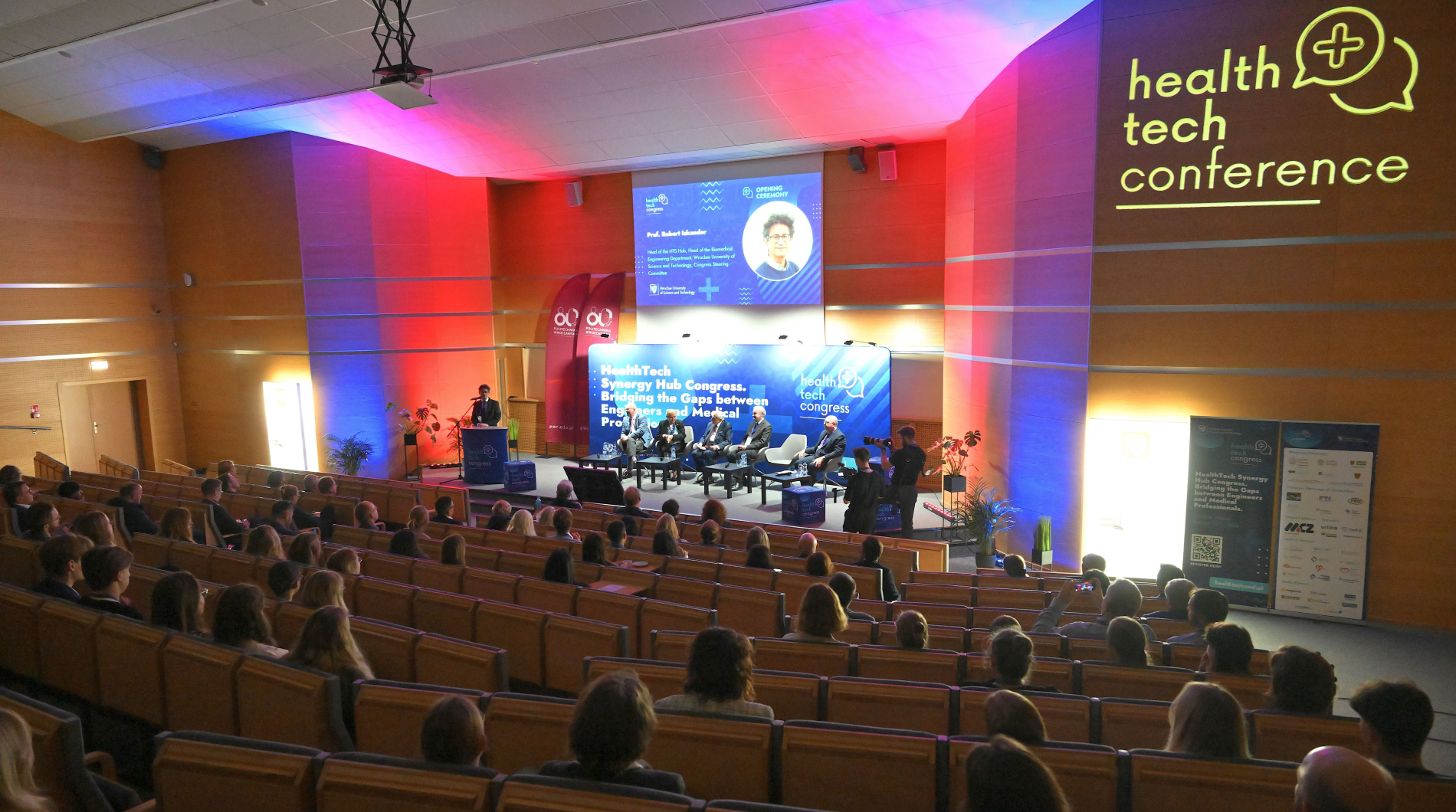Sala konferencyjna z publicznością i panelistami na scenie. Na ekranach widoczny tytuł "Health Tech Congress" i wizerunek prelegenta.