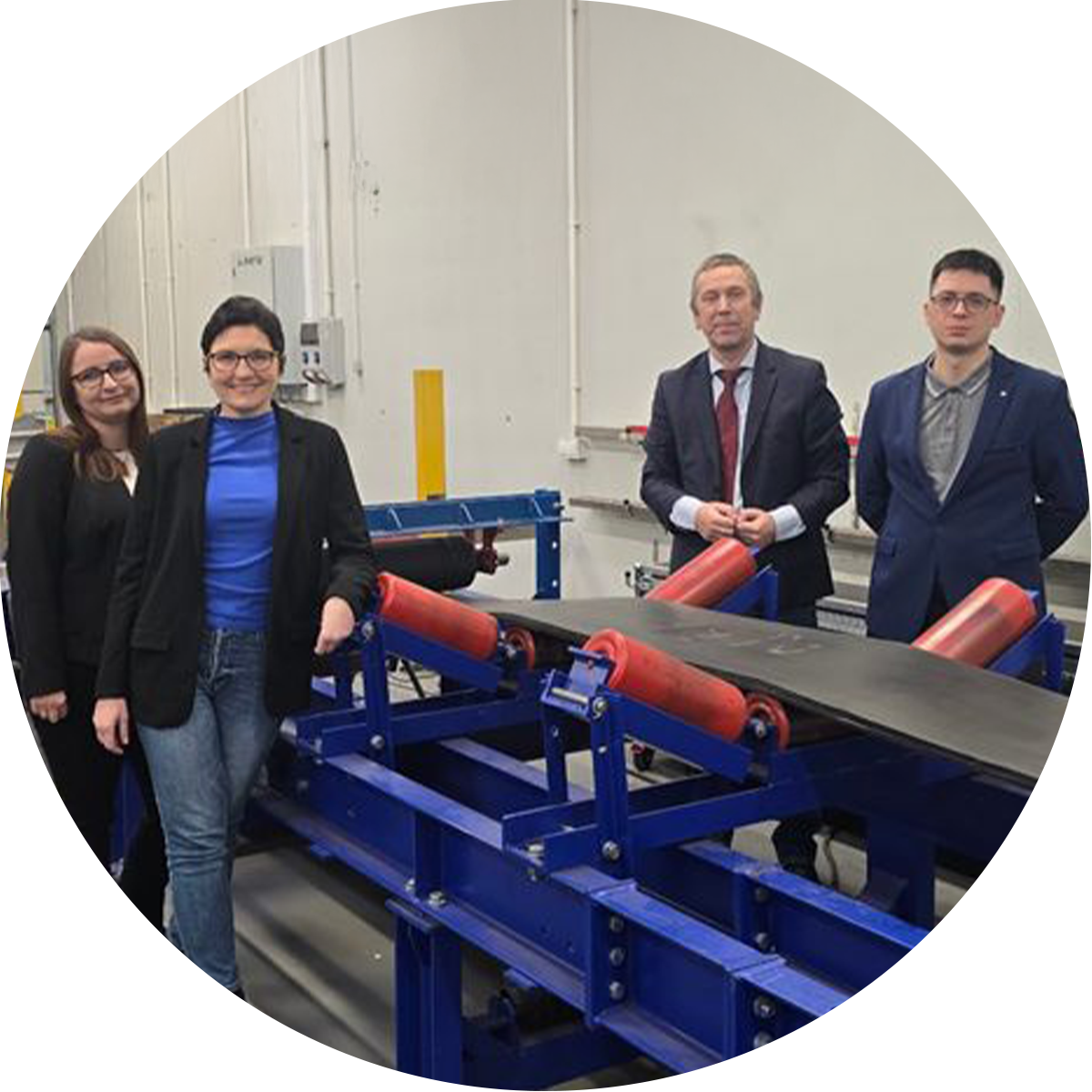 Cztery osoby stojące przy taśmociągu