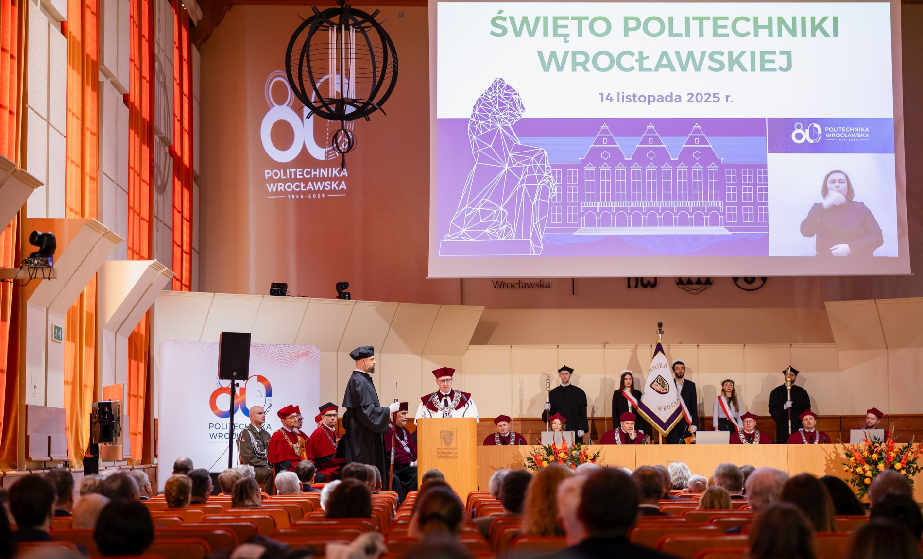 Zdjęcie przemawiającego rektora na auli