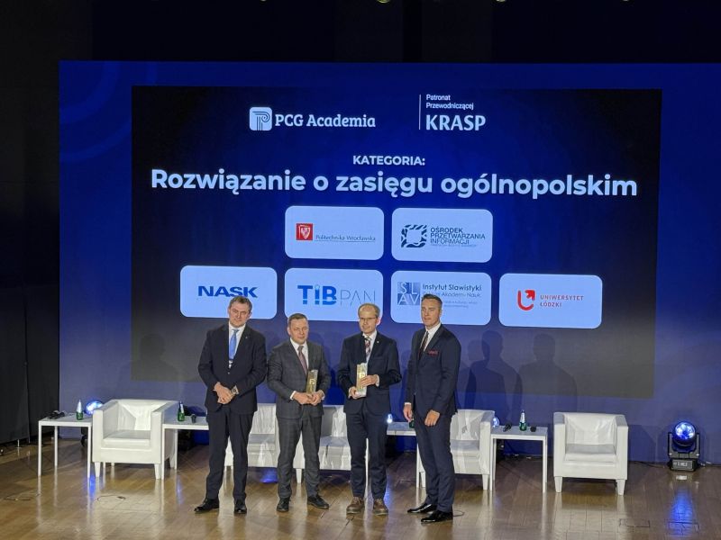 Czterech mężczyzn w garniturach odbiera nagrody na scenie podczas gali PCG Academia pod dużym ekranem z napisami: "KATEGORIA: Rozwiązanie o zasięgu ogólnopolskim" i logo uczelni.