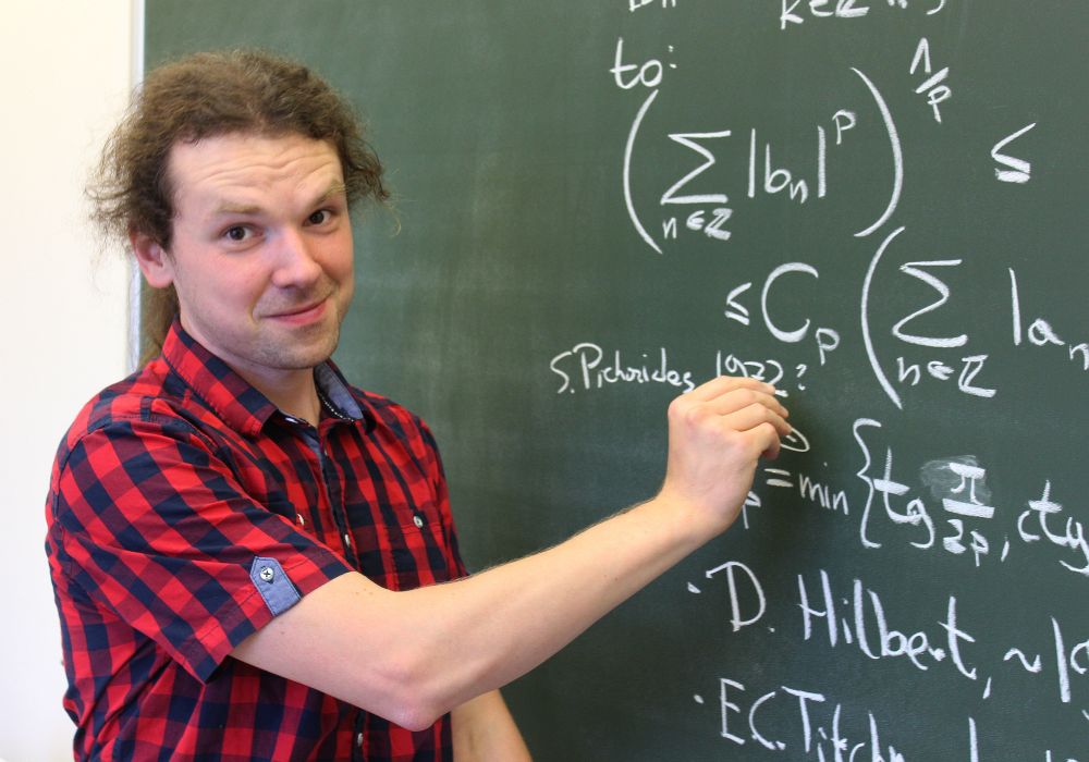 Prof. Mateuz Kwaśnicki przy tablicy rozwiązuje zadania matematyczne