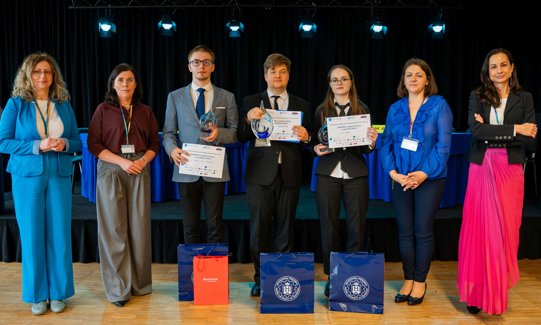 Zdjęcie grupowe laureatów olimpiady z pucharami i dyplomami